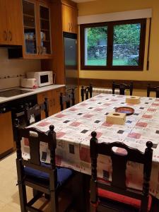 una cocina con una mesa con un edredón en Alojamientos la Abuela en Rascafría