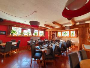 un restaurante con mesas, sillas y paredes rojas en Hotel Lyskamm, en Breuil-Cervinia