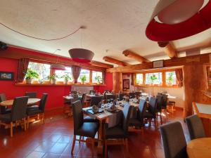 een restaurant met tafels en stoelen en rode muren bij Hotel Lyskamm in Breuil-Cervinia