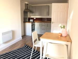 a small kitchen with a wooden table and chairs at GRANBY APARTMENTS F-2 in Leicester