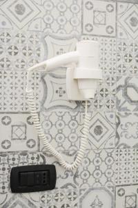 un téléphone avec un cordon suspendu sur un mur dans l'établissement B&B Casa Cupiello, à Naples