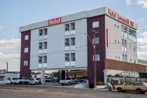 a hotel building with cars parked in front of it at Hotel Lorenzetti BR in Guarapuava
