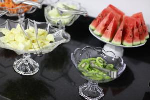 una mesa con tres platos de fruta en tazones de vidrio en Hotel Lorenzetti BR, en Guarapuava