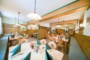 a restaurant with wooden walls and tables and chairs at Hotel zum Kirchenwirt Mariazell in Mariazell