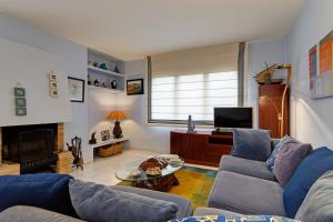 uma sala de estar com um sofá e uma televisão em Ses Brises 2 em Tamariu