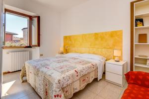 Un dormitorio con una cama grande y una ventana. en Catullo Apartments Sirmione, en Sirmione 45 fotos más
