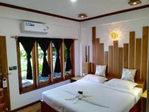 a bedroom with two beds and a window at Mingalar Boutique Hotel in Kawthaung