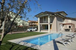 une maison avec une piscine en face d'une maison dans l'établissement Villa Zarina - up to 12 people, à Peschiera del Garda