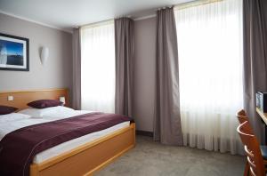 a bedroom with a bed and a large window at Hotel Hafentor in Hamburg