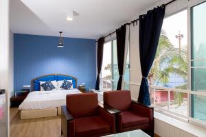 a bedroom with blue walls and a bed and two chairs at Chill Days @ Koh Larn in Ko Larn