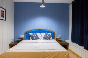 a bedroom with a blue wall with a bed with pillows at Chill Days @ Koh Larn in Ko Larn