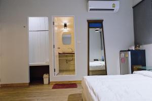 a bedroom with a bed and a bathroom with a mirror at Chill Days @ Koh Larn in Ko Larn