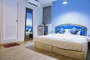 a bedroom with a bed with a blue wall at Chill Days @ Koh Larn in Ko Larn