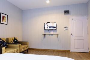 a bedroom with a bed and a couch and a door at Chill Days @ Koh Larn in Ko Larn