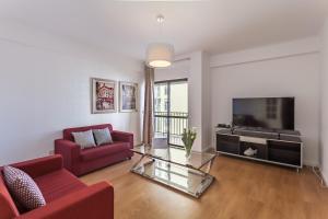 a living room with a red couch and a television at BeGuest Cascais Inn Apartments in Cascais