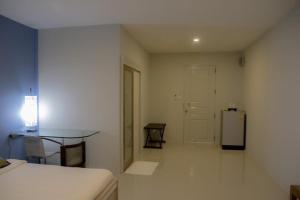 a white room with a table and a refrigerator at Chill Days @ Koh Larn in Ko Larn