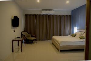 a bedroom with a bed and a desk and a television at Chill Days @ Koh Larn in Ko Larn