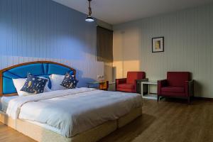 a bedroom with a bed and two red chairs at Chill Days @ Koh Larn in Ko Larn
