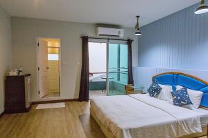 a bedroom with a large bed and a balcony at Chill Days @ Koh Larn in Ko Larn
