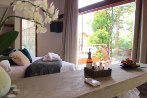 a living room with a table and a large window at Pousada Santa Vila in Serra do Cipo