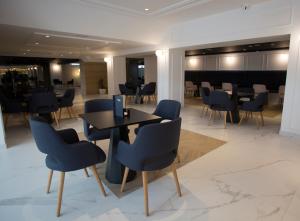 a dining room with blue chairs and a table at Hotel Voramar in Benidorm