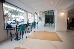 a restaurant with a bar with green stools at Hotel Voramar in Benidorm