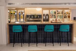 a bar with blue bar stools in a store at Hotel Voramar in Benidorm