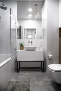 een witte badkamer met een wastafel en een toilet bij MyCherry - Old Town Apartment - Księcia Witolda 27 in Wrocław