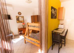 Habitación con escritorio, litera y mesa. en Apartman Punta Vilma, en Pula