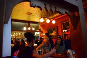 a group of people sitting at a bar in a restaurant at Grand Imperial Hotel in Silverton