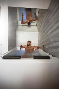 un homme dans une baignoire avec une photo d'un homme en train de se coucher dans l'établissement Love in the Loft, à Babilafuente