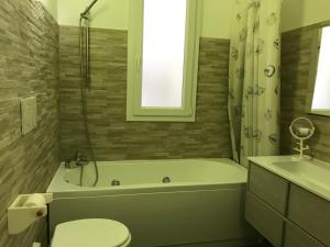 a bathroom with a tub and a toilet and a sink at Casa del sasso in Bergeggi +37 photos