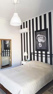 ein Schlafzimmer mit einem Bett mit einer schwarz-weißen gestreiften Wand in der Unterkunft HOME RESORT in Kalamata