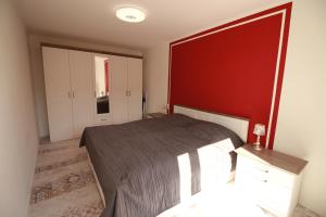 バート・ノイェンアール・アールヴァイラーにあるFerienwohnung Bad Neuenahr Kurviertelの赤い壁のベッドルーム1室(ベッド1台付)