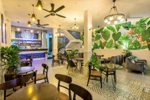 Un restaurante con mesas y sillas y un bar. en Square Villa Hoi An, en Hoi An