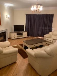 a living room with two couches and a tv at Adelaide's holiday home in Modbury