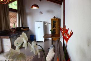 a kitchen with a white refrigerator and a table at Pousada Santa Vila in Serra do Cipo