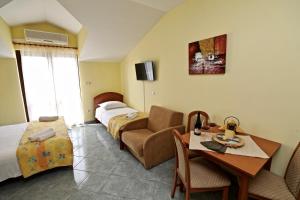 a hotel room with a bedroom with a bed and a table at Apartments IDA Sucuraj in Sućuraj