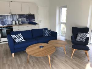 Una sala de estar con un sofá azul y una mesa. en SEASIDE APARTMENTS - BEACHHOUSE SKY, en Eckernförde