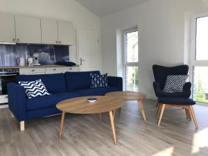 un soggiorno con divano blu e tavolo di SEASIDE APARTMENTS - BEACHHOUSE SKY a Eckernförde