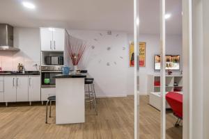 cocina con armarios blancos y encimera en una habitación en Apartamento San Isidro, OZONO, en Granada