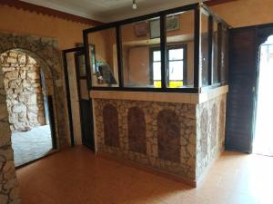 Auberge Restaurant Telouet في Telouet: غرفة بجدار حجري مع نافذة زجاجية