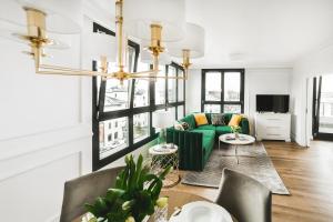 a living room with a green couch and a table at Apartament Golden Place 2 in Kraków