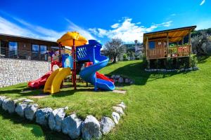 a playground with a slide in the grass at GeoResort in Tremosine Sul Garda