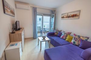 a living room with a purple couch and a table at Apartment San Marco in Risan