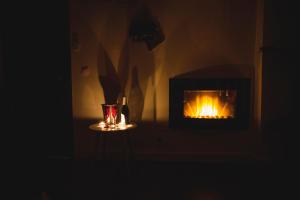 a dark room with a fireplace and a bottle of wine at Junior Suites con Jacuzzi in Babilafuente