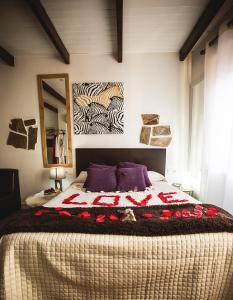 Un dormitorio con una cama grande con flores rojas. en Junior Suites con Jacuzzi, en Babilafuente