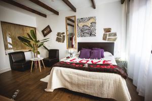 een slaapkamer met een groot bed en 2 stoelen bij Junior Suites con Jacuzzi in Babilafuente