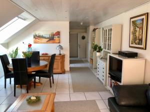 a living room with a table and a tv at Annes Ferienwohnung Freiburg in Vörstetten