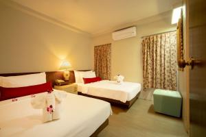 a hotel room with two beds and a window at Villa Cha-Cha Banglumphu in Bangkok